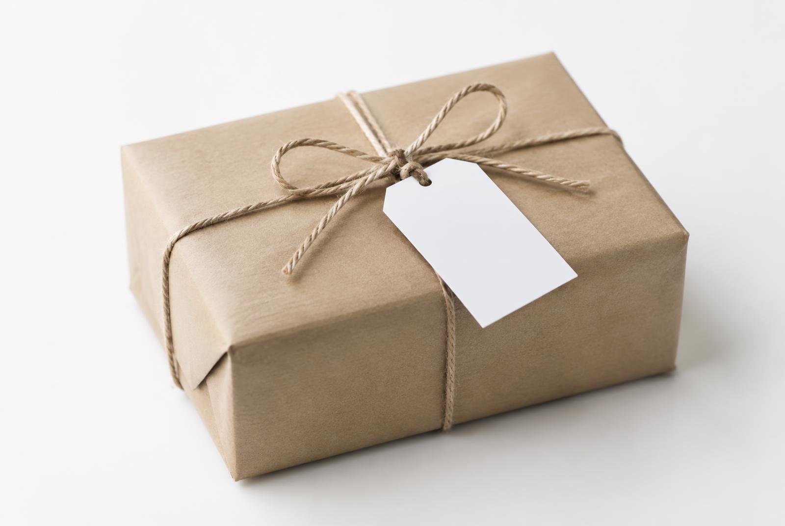 A kraft paper package tied with twine and a blank white label.